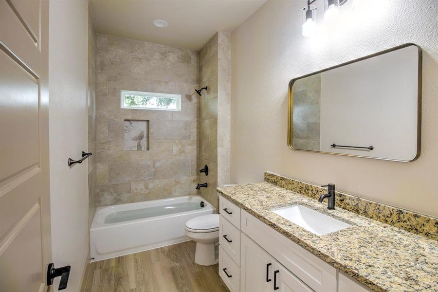 Bathroom featuring shower / bath combination, vanity, and light wood-type flooring