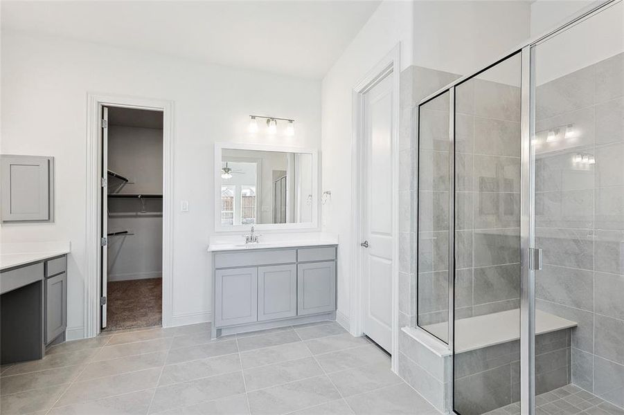 Full bathroom featuring vanity, a stall shower, light tile patterned floors, and a spacious closet