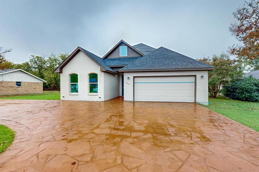 View of front facade with a garage and a front lawn