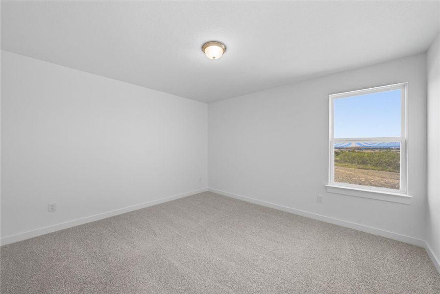 Spare room with light carpet and baseboards Spare room with light carpet and baseboards