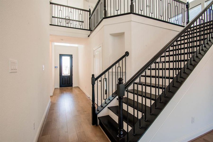 Foyer entrance featuring wood-type flooring and a high ceiling