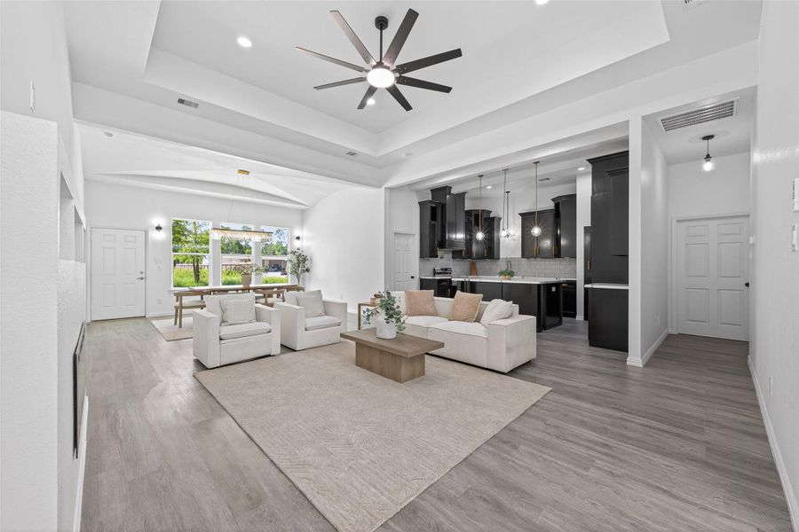 Bright and spacious open-concept living area featuring beautiful laminate flooring, abundant natural light, and custom finishes throughout.