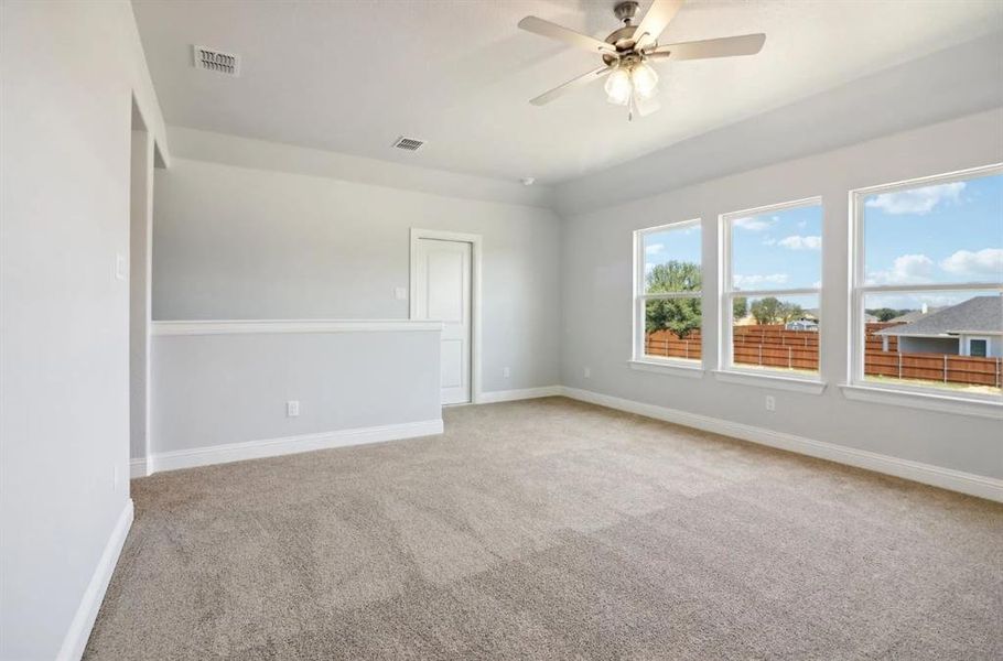 Spare room featuring carpet flooring and ceiling fan