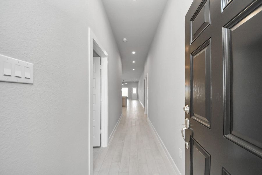 As you step into the threshold of this luxurious home, you'll soon be welcomed by an elegant glass door (to be installed). Inside, soaring ceilings amplify the spaciousness, while the refined wood-look tile flooring and oversized baseboards exude sophistication and charm. Sample photo of completed home with similar floor plan. Actual colors and selections may vary.