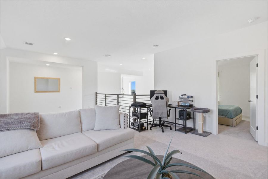 Carpeted living room featuring recessed lighting and baseboards