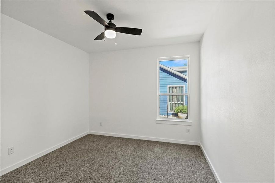 Carpeted empty room with ceiling fan