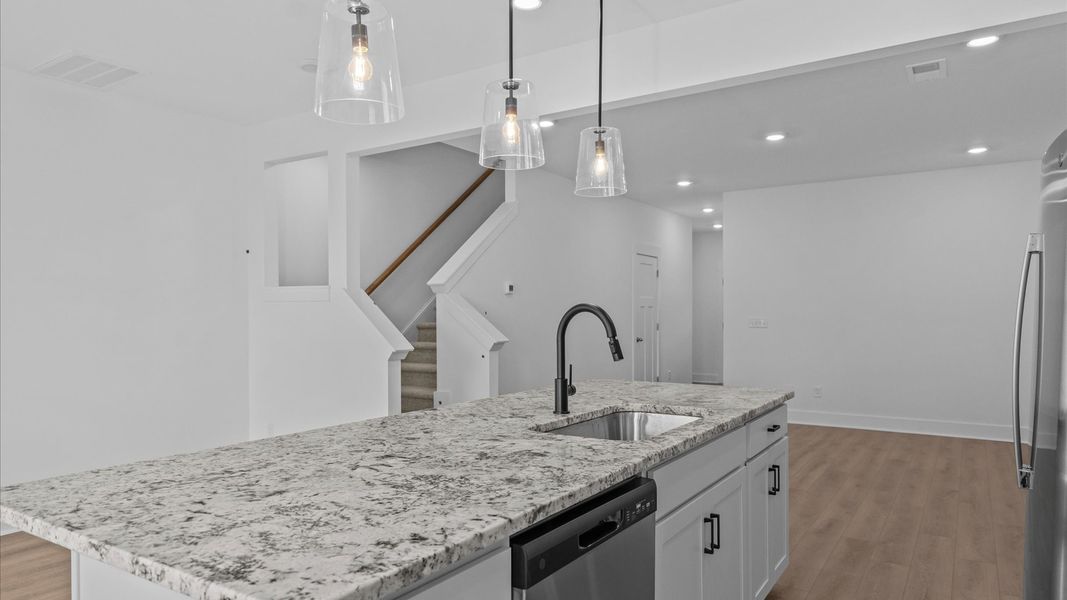 First-class kitchen with a spacious 9-foot island perfect for entertaining beneath designer pendant lighting First-class kitchen with a spacious 9-foot island perfect for entertaining beneath designer pendant lighting