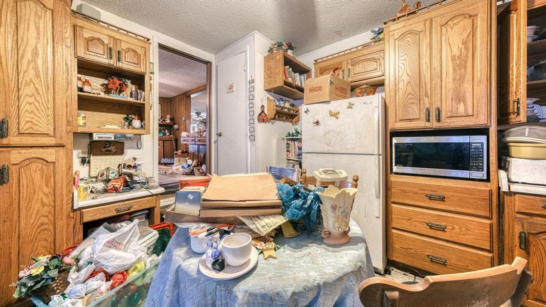 Kitchen featuring white fridge and a textured ceiling