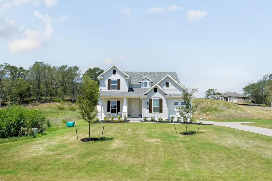 Front exterior of a new home in Double Eagle Ranch, Cedar Creek, TX, highlighting curb appeal (Image 1).