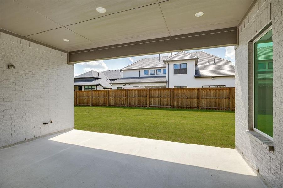Covered patio with recessed lighting, concrete flooring, and painted brick walls Covered patio with recessed lighting, concrete flooring, and painted brick walls