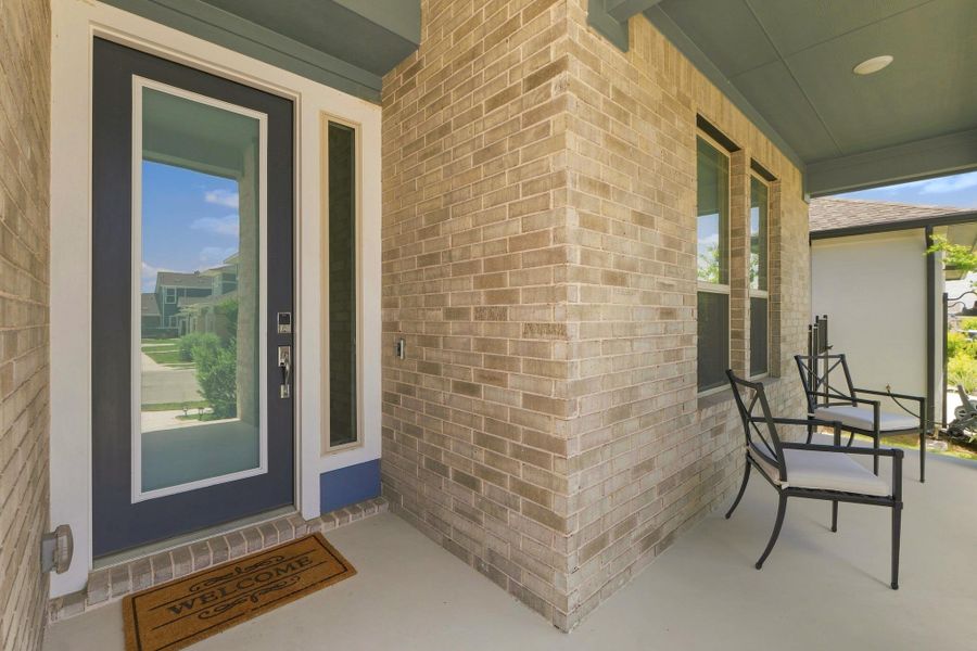 Charming covered front porch showcasing the upgraded 8-foot frosted glass front door with chrome Addison hardware. Charming covered front porch showcasing the upgraded 8-foot frosted glass front door with chrome Addison hardware.