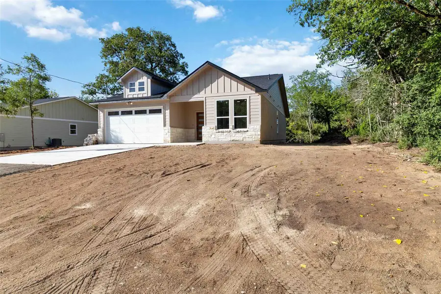 View of front of property with stone siding, concrete driveway, board and batten siding, and a garage View of front of property with stone siding, concrete driveway, board and batten siding, and a garage