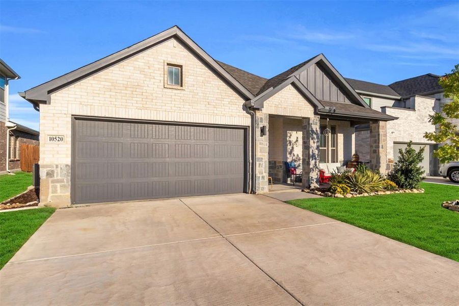 View of front of property with a front yard and a garage