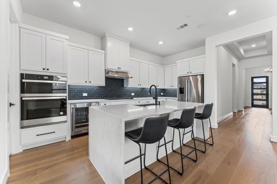 Built-in wall oven and microwave combo, stainless steel appliances, and quartz counters — a kitchen that actually makes cooking enjoyable.