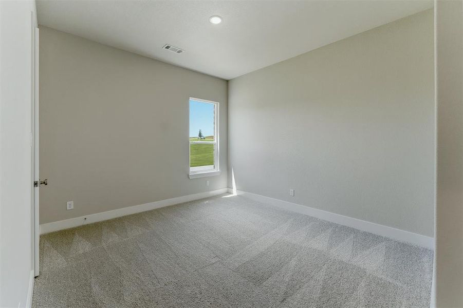 Room featuring neutral wall paint, patterned carpeting, and a single window offering exterior scenery