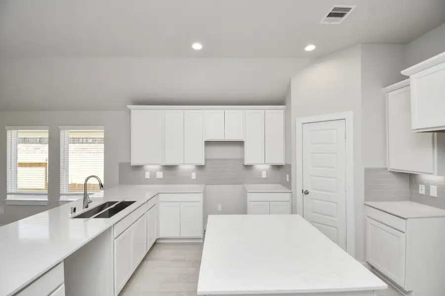 The kitchen is a culinary haven, featuring granite countertops, a tile backsplash, stainless steel appliances, 42” upper cabinets, and undercabinet lighting. Sample photo of completed home with similar floor plan. Actual colors and selections may vary. The kitchen is a culinary haven, featuring granite countertops, a tile backsplash, stainless steel appliances, 42” upper cabinets, and undercabinet lighting. Sample photo of completed home with similar floor plan. Actual colors and selections may vary.