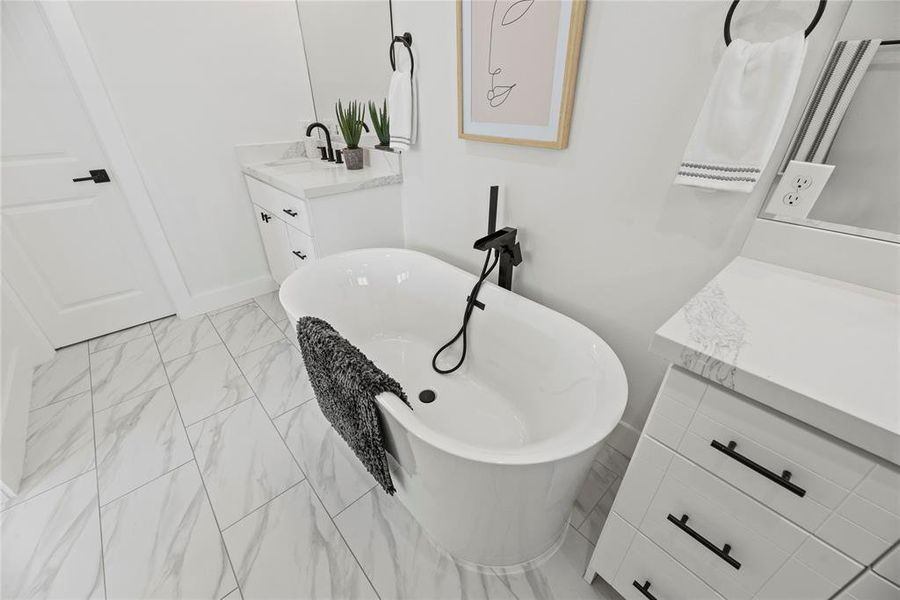 Stretch out for a luxurious bath in this spa-like bathroom.  The door leads to a private water closet.