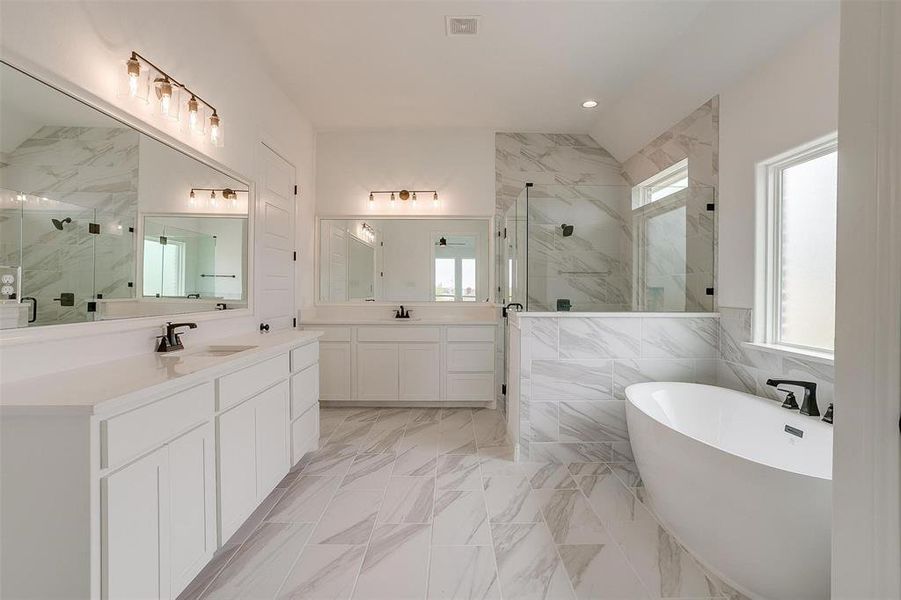 Bathroom featuring vanity, shower with separate bathtub, and tile walls