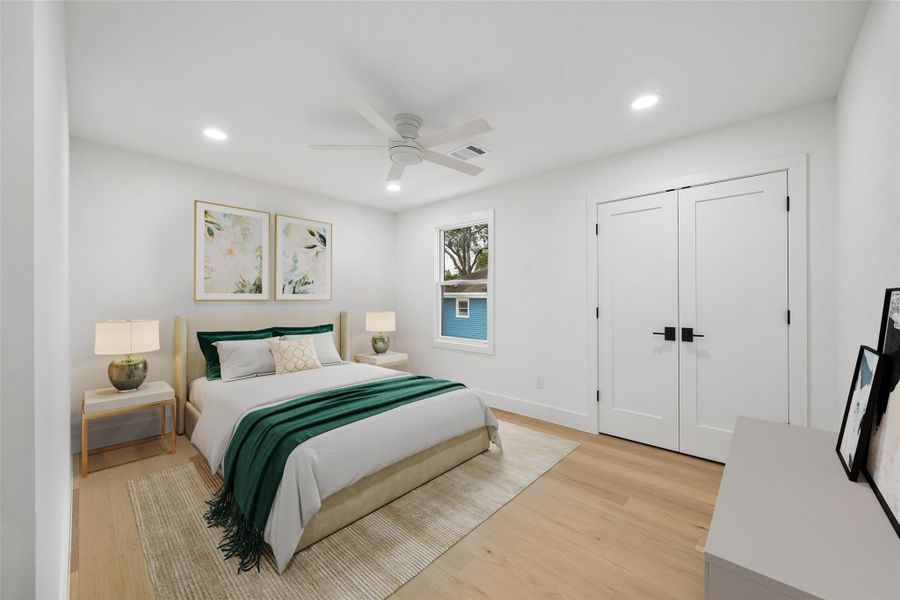 The secondary bedroom maintains the home’s cohesive contemporary aesthetic with recessed lighting, neutral finishes, and a spacious layout designed to comfortably accommodate a variety of living arrangements. (digitally staged)