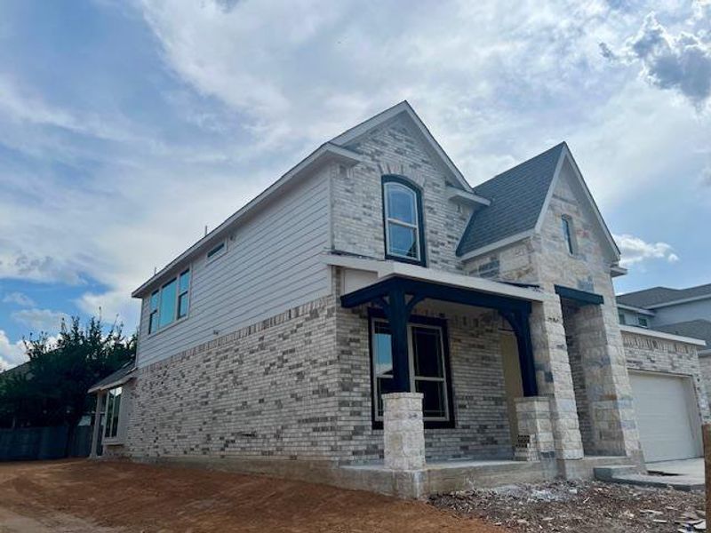 View of side of home featuring covered porch and brick siding View of side of home featuring covered porch and brick siding