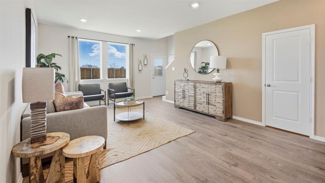 Living room with light wood-type flooring and recessed lighting