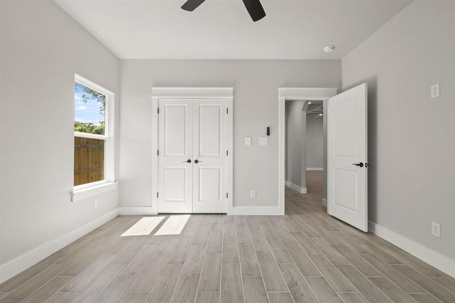 Unfurnished bedroom with light wood finished floors, baseboards, and ceiling fan