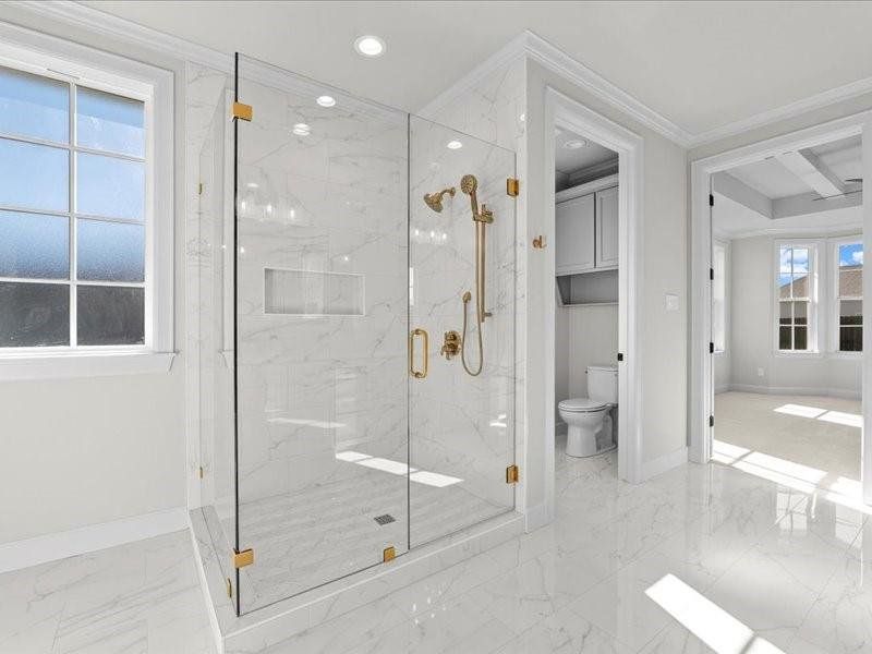Bathroom with a marble finish shower, light marble finish floors, crown molding, and recessed lighting Bathroom with a marble finish shower, light marble finish floors, crown molding, and recessed lighting