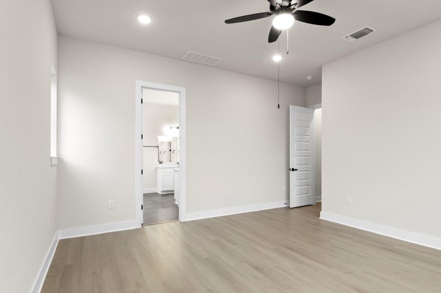 Unfurnished bedroom with a ceiling fan, light wood finished floors, connected bathroom, and recessed lighting