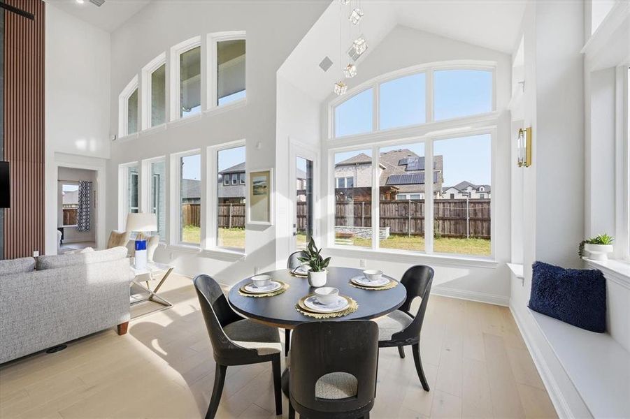 Bright dining area featuring a vaulted ceiling and an array of large windows