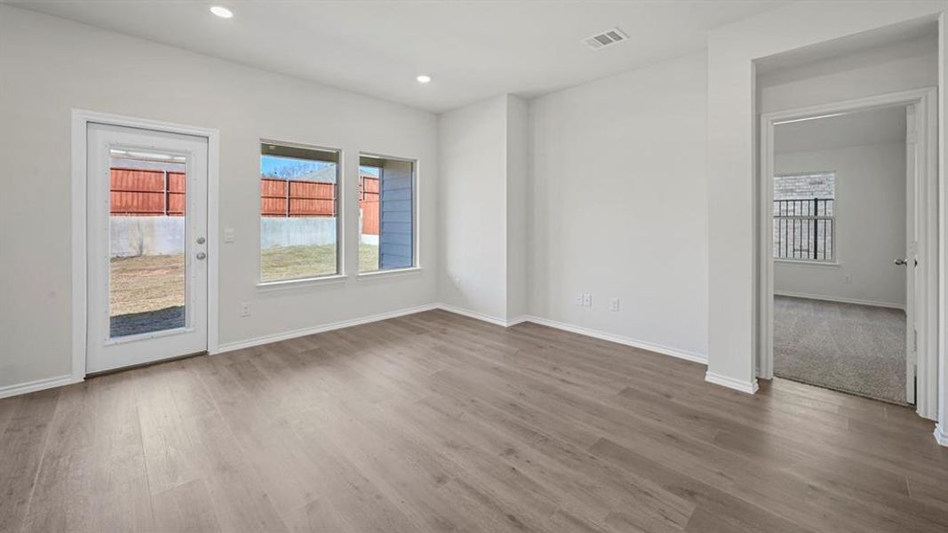 Empty room with light wood-style flooring and recessed lighting