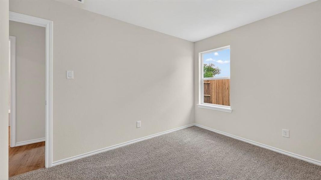 Neutral-toned room featuring light gray walls, white trim, and gray carpeted flooring