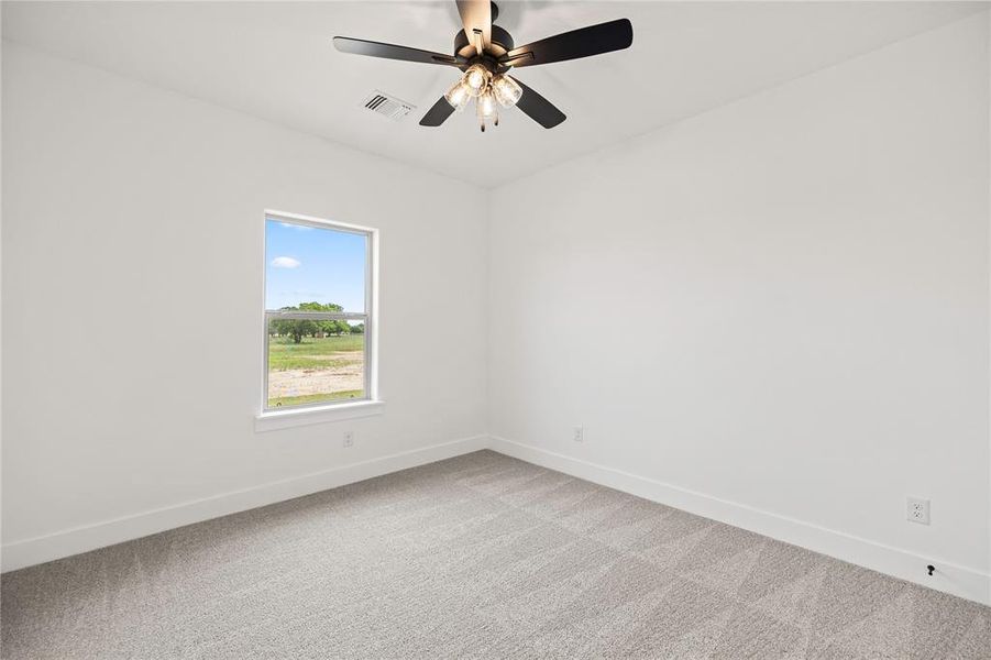 Empty room featuring light colored carpet and a ceiling fan Empty room featuring light colored carpet and a ceiling fan