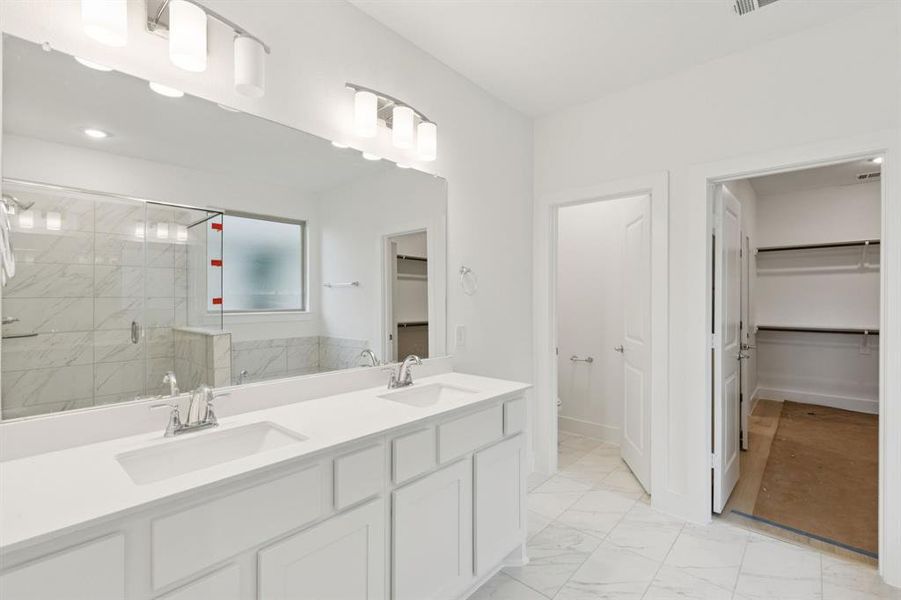 Bathroom featuring a walk in closet, a shower stall, double vanity, marble finish flooring, and recessed lighting Bathroom featuring a walk in closet, a shower stall, double vanity, marble finish flooring, and recessed lighting