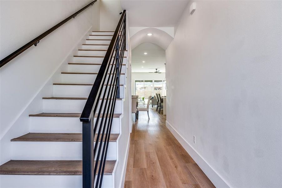 Stairway with wood finished floors, recessed lighting, and arched walkways Stairway with wood finished floors, recessed lighting, and arched walkways