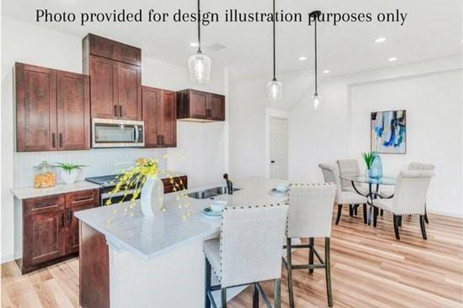 Example of kitchen featuring range, pendant lighting, sink, a center island with sink, and light hardwood / wood-style flooring