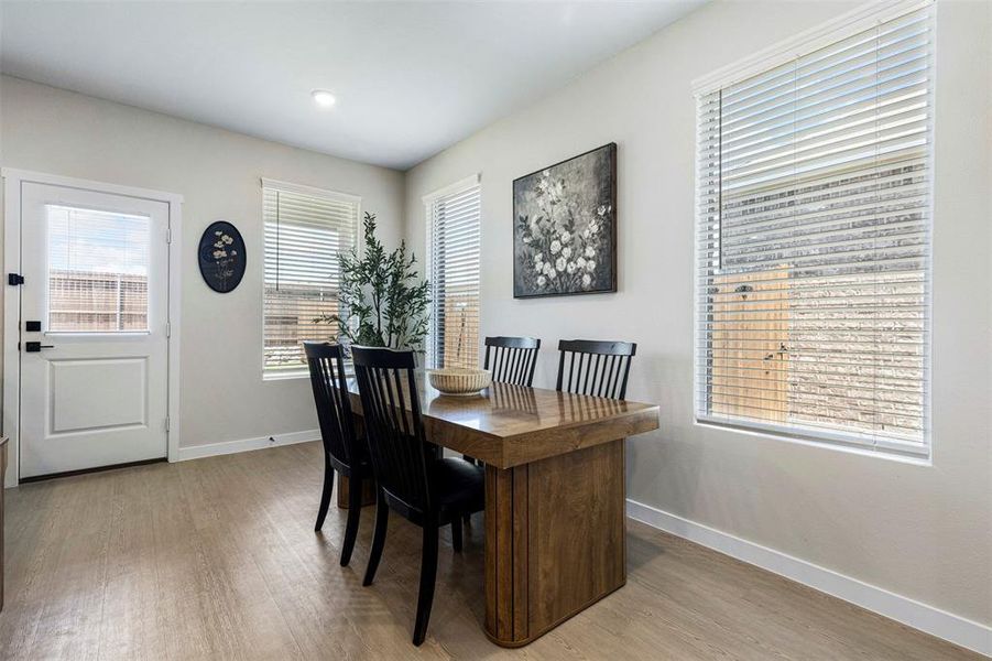 Dining area featuring wood-finish flooring and light-toned walls Dining area featuring wood-finish flooring and light-toned walls