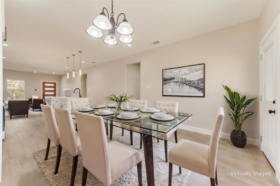 Dining area featuring ceiling fan with notable chandelier and light hardwood / wood-style flooring