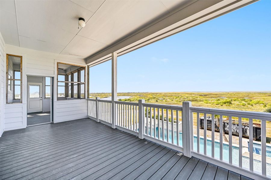 The expansive covered porch was designed for year round outdoor living and entertaining. Lounge in the shade while overlooking sparkling water, lush greens, and endless coastal scenery.