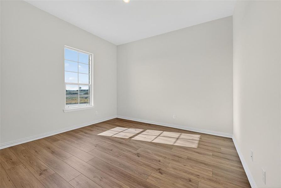 Empty room with light wood-style flooring and baseboards