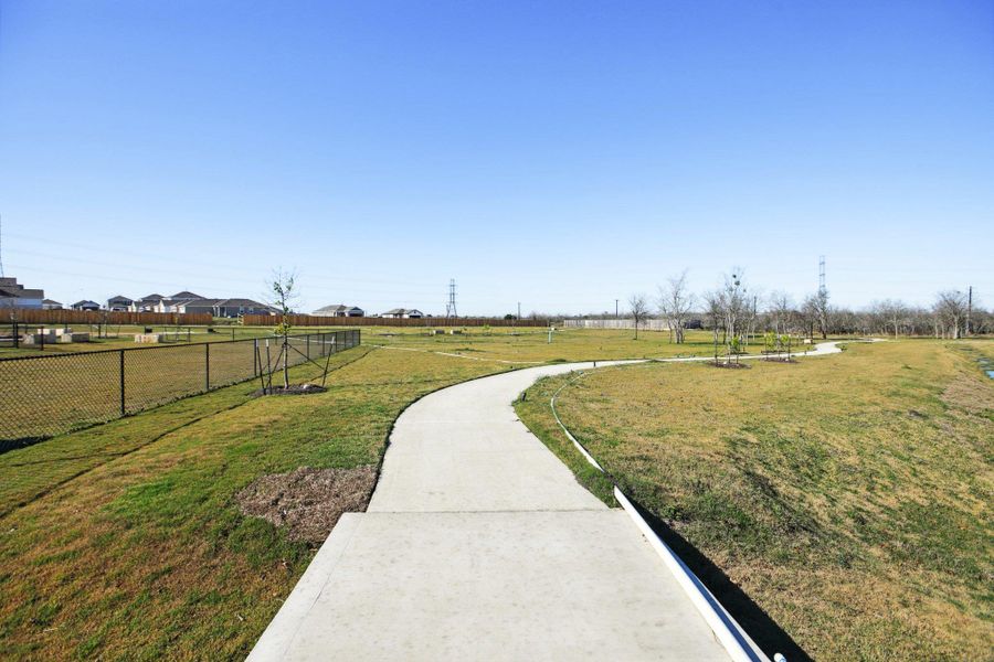 View of community with fence and a lawn