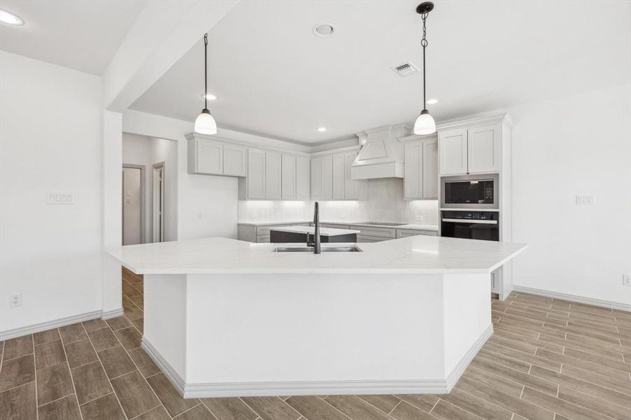 Kitchen with built in microwave, sink, oven, and a spacious island