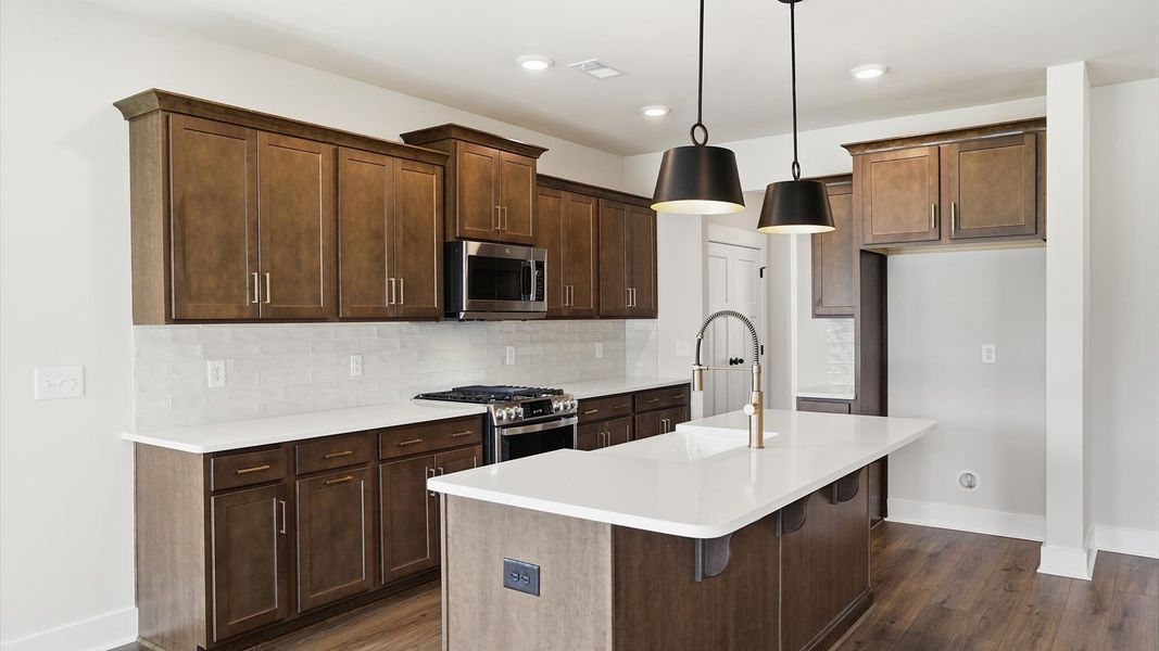 Well-designed kitchen with a center island and tasteful finishes that elevate everyday living by DRB Homes Well-designed kitchen with a center island and tasteful finishes that elevate everyday living by DRB Homes