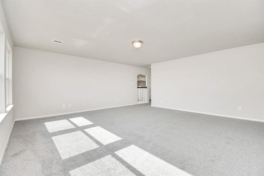 Upstairs game room featuring plush carpet and large windows.