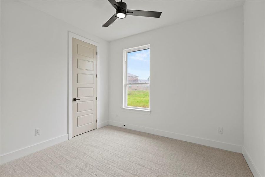 Unfurnished room featuring light carpet and a ceiling fan Unfurnished room featuring light carpet and a ceiling fan
