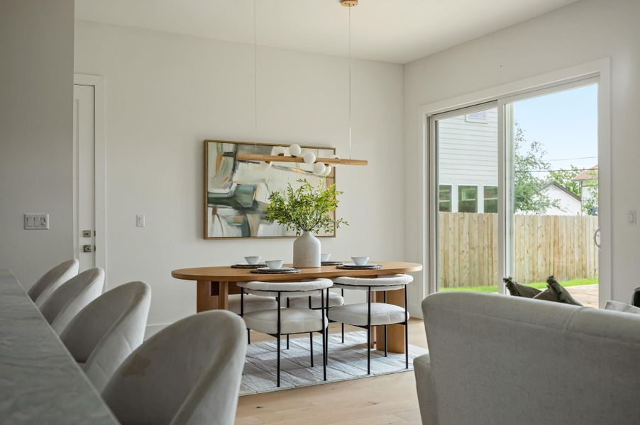 Hardwood floors and a modern light fixture enhance this inviting dining space, offering direct access to the outdoors. Hardwood floors and a modern light fixture enhance this inviting dining space, offering direct access to the outdoors.