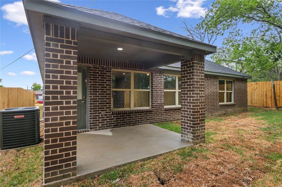 Rear view of house featuring cooling unit and a patio area