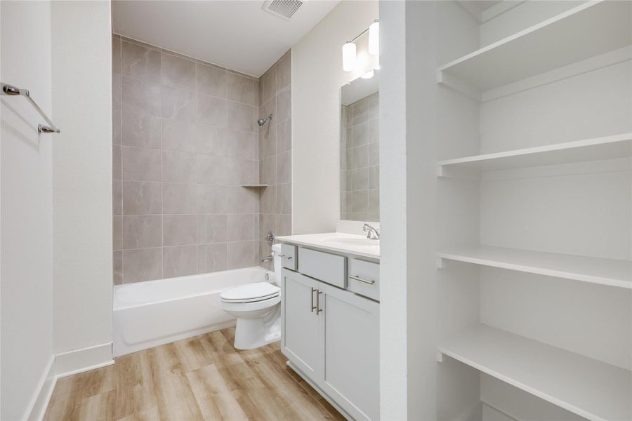 Full bathroom with vanity, shower / bathtub combination, and light wood-type flooring Full bathroom with vanity, shower / bathtub combination, and light wood-type flooring