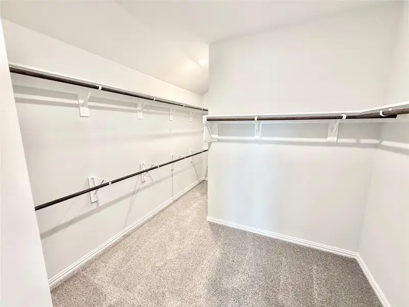 Spacious closet with carpet flooring and lofted ceiling Spacious closet with carpet flooring and lofted ceiling