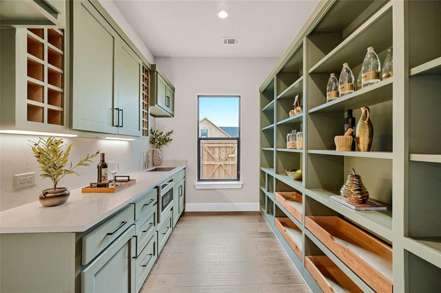 Working pantry with quartz counters, microwave, wine storage, sink, room for 2nd fridge