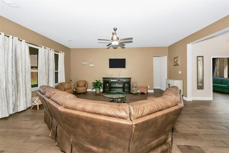 Living room with radiator heating unit, hardwood / wood-style flooring, and ceiling fan